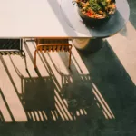 Tables, chairs, and shadows creating a sunny scene.